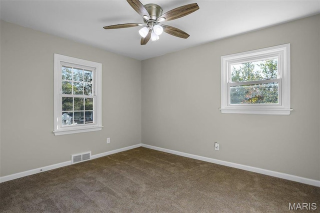 4000 Washington St, Florissant, MO 63033 - unfurnished room with dark carpet, healthy amount of natural light, baseboards, and ceiling fan