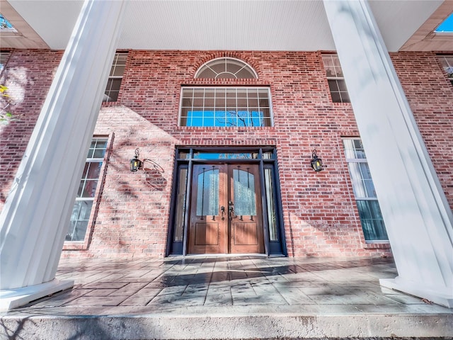 property entrance with french doors and brick siding