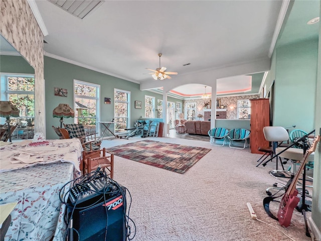 carpeted living area featuring ornamental molding, plenty of natural light, a ceiling fan, and arched walkways