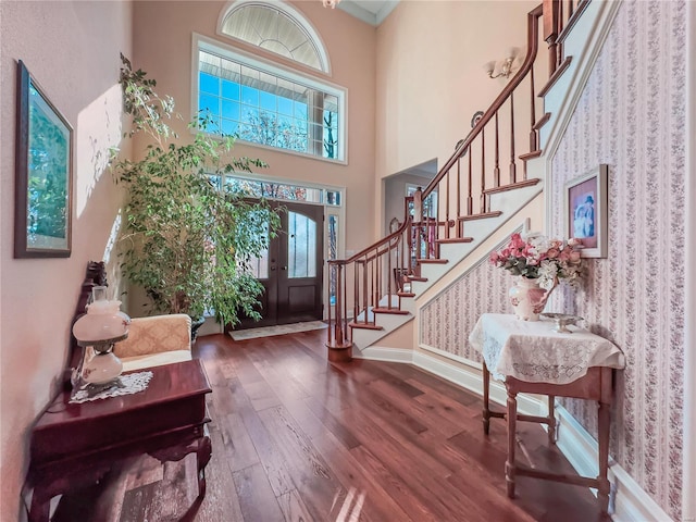 entryway featuring hardwood / wood-style floors, stairs, french doors, healthy amount of natural light, and a high ceiling