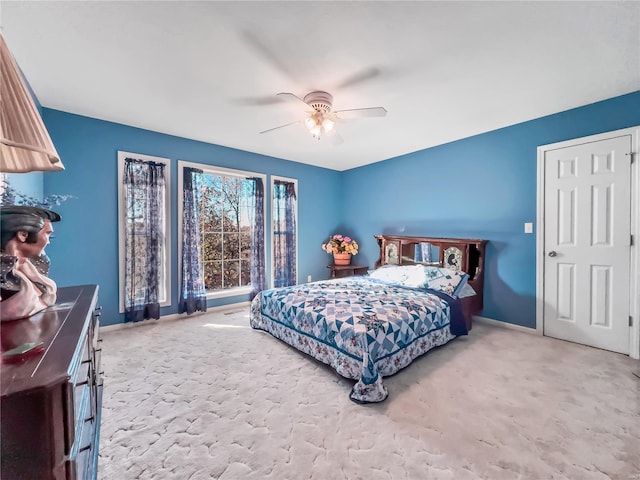 carpeted bedroom featuring baseboards and a ceiling fan