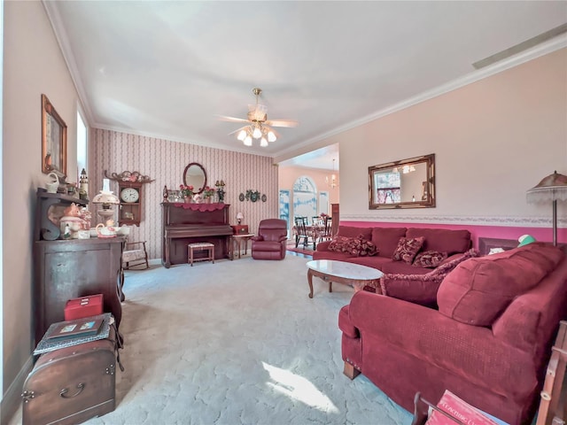 living room featuring wallpapered walls, ornamental molding, ceiling fan, carpet, and a chandelier
