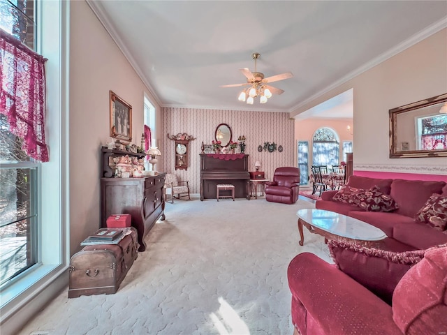 carpeted living room with crown molding, wallpapered walls, and a ceiling fan