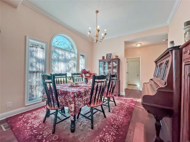 dining space with ornamental molding, a chandelier, baseboards, and dark wood-style flooring