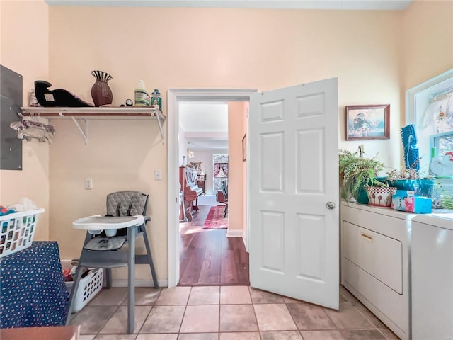 clothes washing area with washing machine and clothes dryer and light tile patterned floors