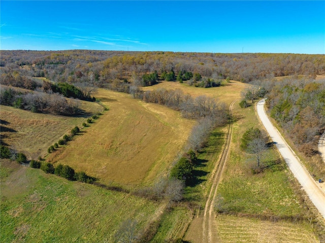 aerial view of property and surrounding area with a heavily wooded area