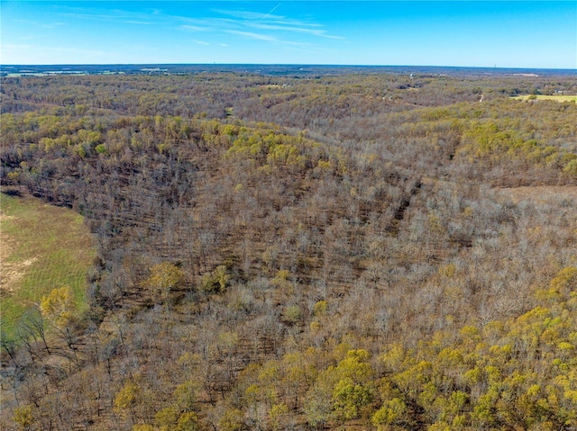 aerial view of property and surrounding area with a heavily wooded area