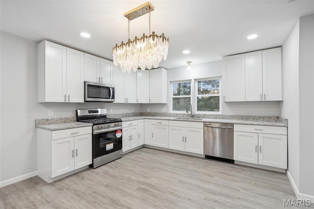 1005 Belleau Creek Rd, Saint Peters, MO 63366 - kitchen featuring appliances with stainless steel finishes, a sink, a chandelier, light wood finished floors, and white cabinets