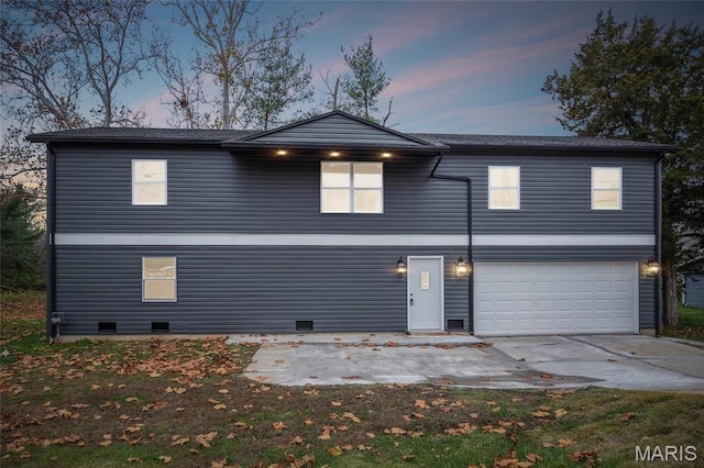 1005 Belleau Creek Rd, Saint Peters, MO 63366 - back of property at dusk with an attached garage and driveway