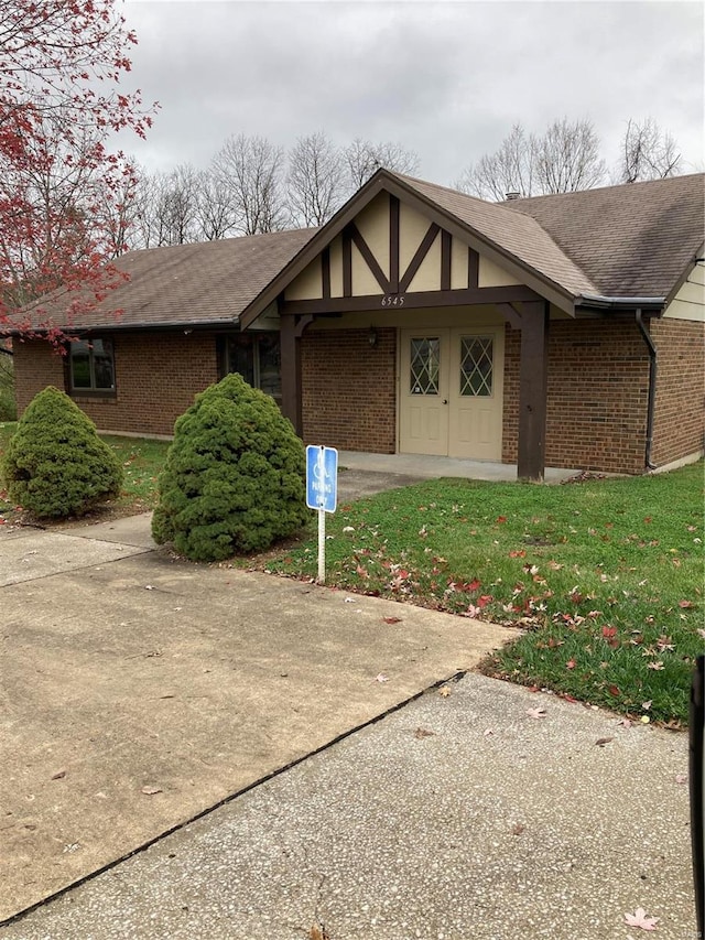 6550 E Dolphin Cir E, Florissant, MO 63033 - property entrance with brick siding, a shingled roof, and a yard
