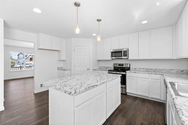 3139 White Pine Dr, Imperial, MO 63052 - kitchen with stainless steel appliances, dark wood finished floors, a center island, recessed lighting, and white cabinets