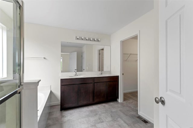 3139 White Pine Dr, Imperial, MO 63052 - full bathroom featuring a walk in closet, a garden tub, double vanity, baseboards, and an enclosed shower