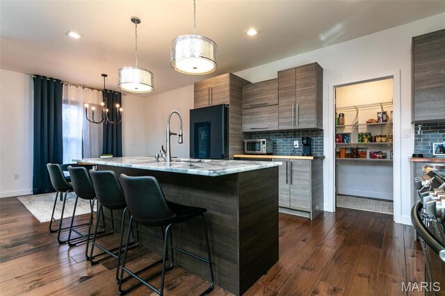 3723 Cabernet Ln, Edwardsville, IL 62025 - kitchen featuring modern cabinets, a breakfast bar, fridge, a center island with sink, and dark wood-style flooring