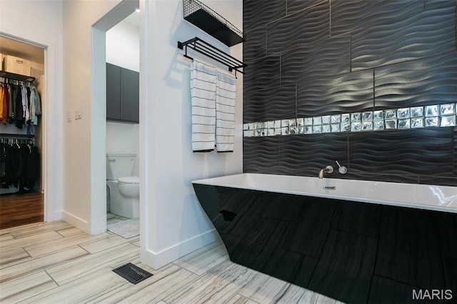 3723 Cabernet Ln, Edwardsville, IL 62025 - full bathroom featuring baseboards, a freestanding bath, toilet, wood tiled floors, and a walk in closet
