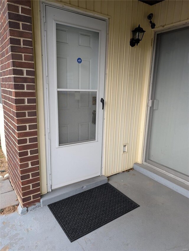 property entrance with brick siding and board and batten siding
