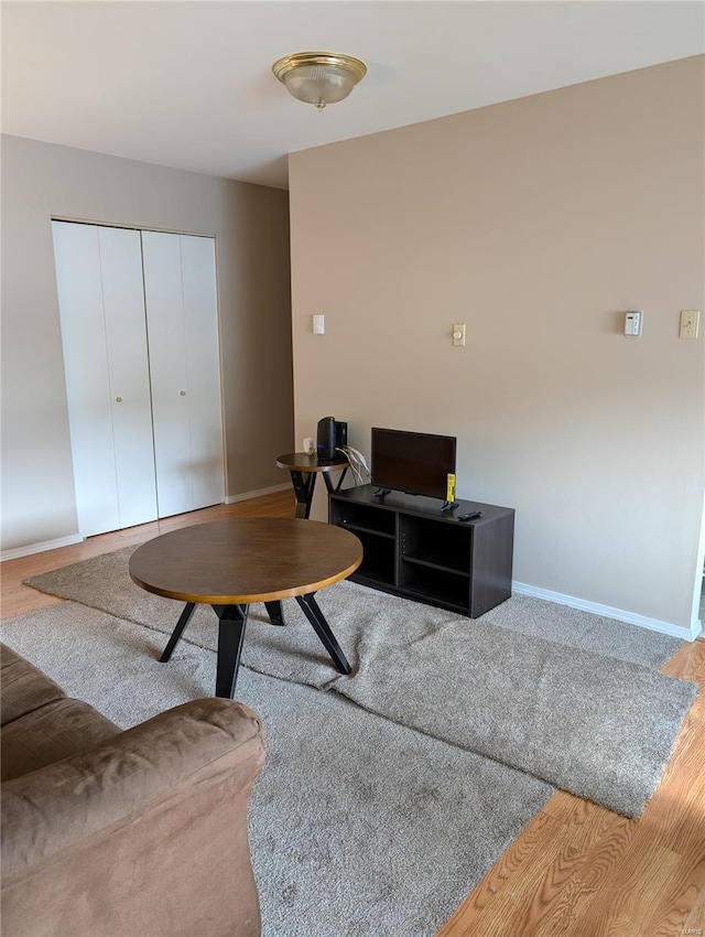 living room with baseboards, wood finished floors, and an office area