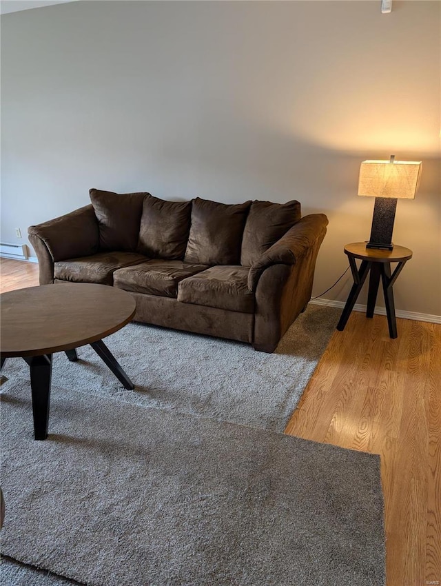 living area with light wood-style flooring, a baseboard radiator, and baseboards