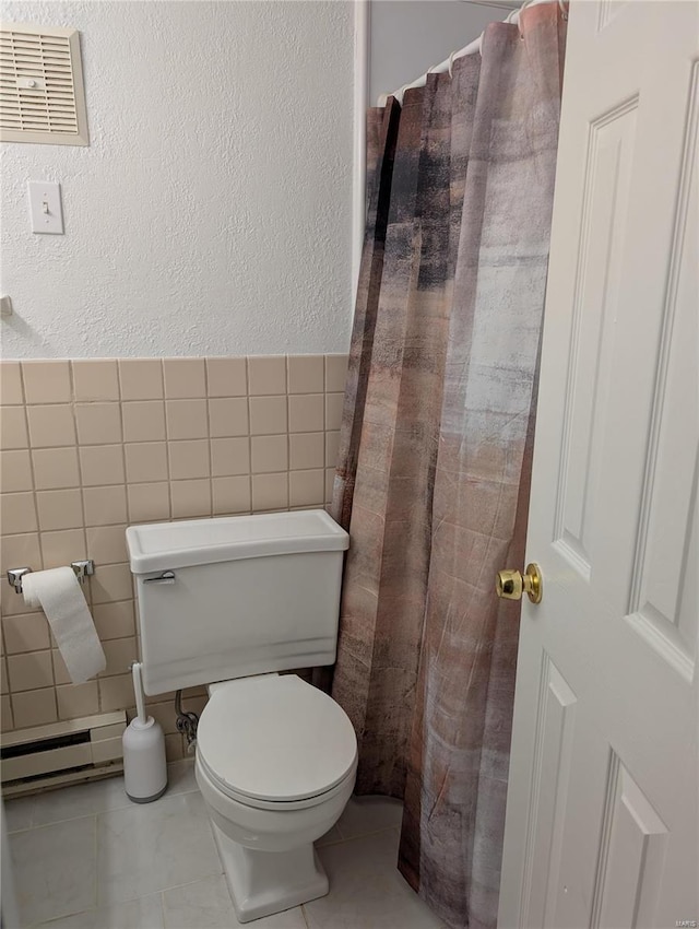 bathroom featuring a baseboard radiator, tile walls, toilet, a textured wall, and tile patterned floors