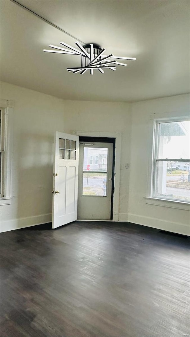 entrance foyer with baseboards, dark wood-style floors, and a chandelier