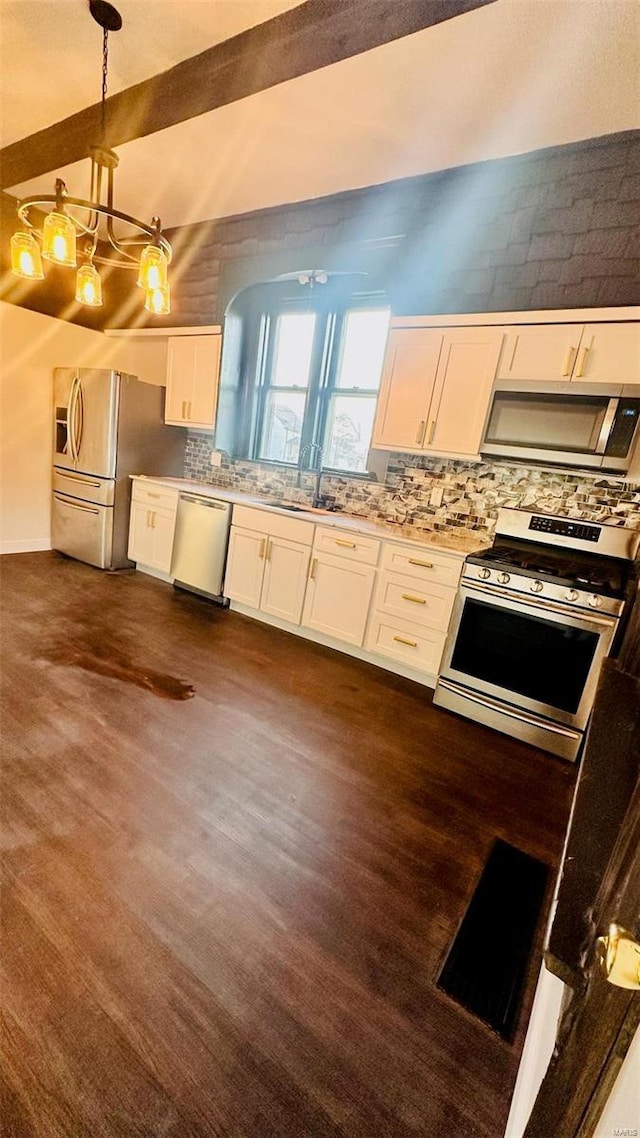 kitchen with stainless steel appliances, decorative backsplash, white cabinets, beam ceiling, and dark wood-type flooring