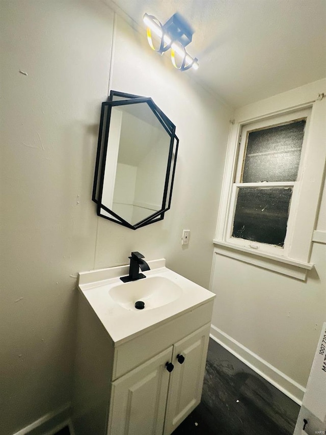 bathroom with vanity, wood finished floors, and baseboards
