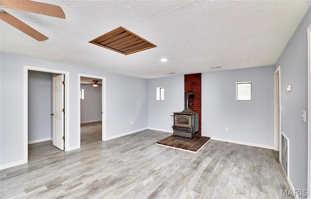 10994 Webster Rd, Caledonia, MO 63631 - unfurnished living room with ceiling fan, a textured ceiling, wood finished floors, a wood stove, and recessed lighting