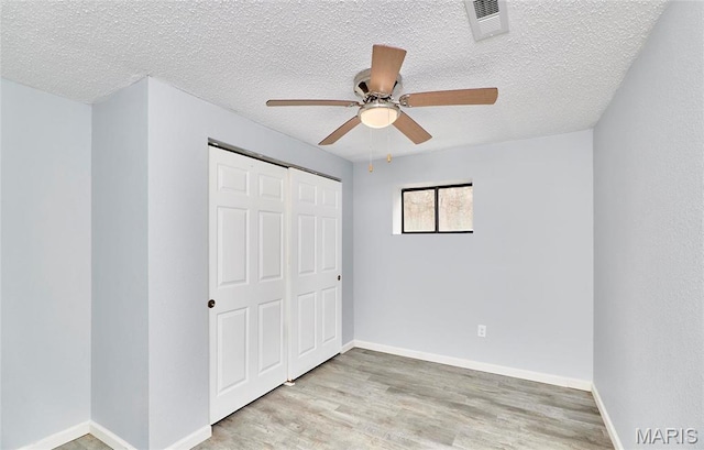 10994 Webster Rd, Caledonia, MO 63631 - unfurnished bedroom featuring a closet, light wood-style flooring, a textured ceiling, and a ceiling fan