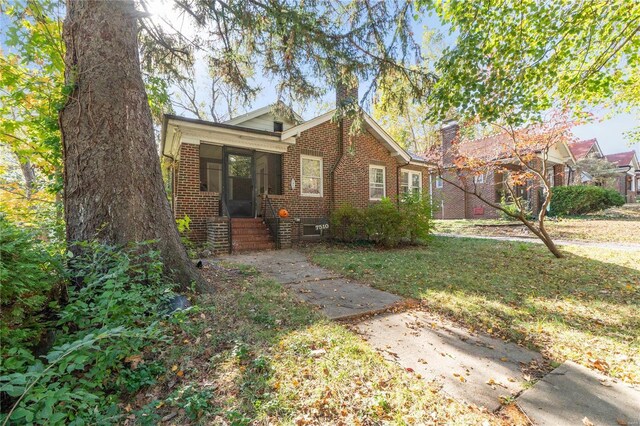 7510 Springdale Dr, Saint Louis, MO 63121 - view of front of home with brick siding, a chimney, and a front lawn