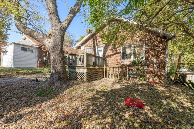 7510 Springdale Dr, Saint Louis, MO 63121 - rear view of house featuring brick siding, a deck, and a chimney