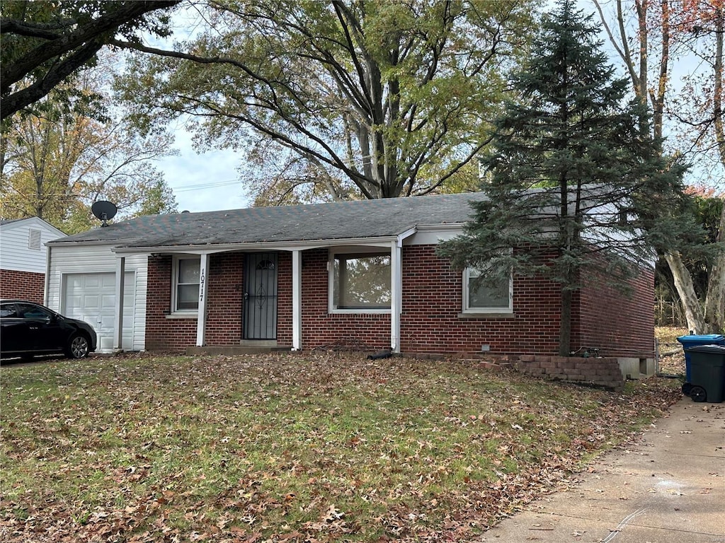 single story home with brick siding, a garage, roof with shingles, and a front lawn