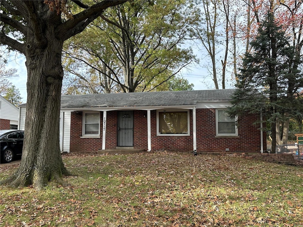 ranch-style house featuring brick siding and a shingled roof