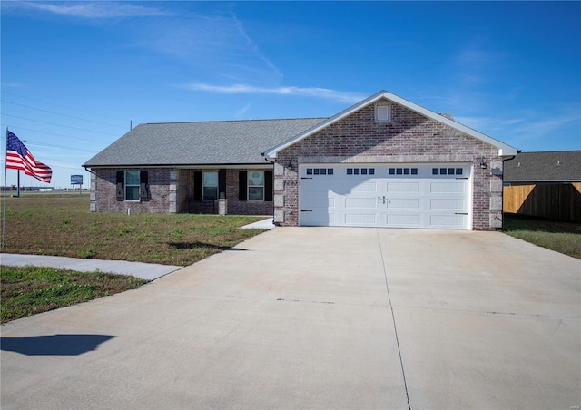 single story home with a garage, brick siding, driveway, and fence
