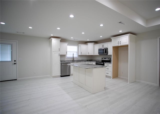 kitchen with stainless steel appliances, baseboards, light wood finished floors, and recessed lighting