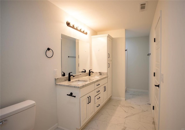 full bathroom featuring marble look tiles, toilet, double vanity, and baseboards