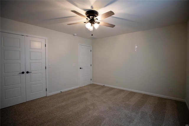unfurnished bedroom with carpet flooring, baseboards, a closet, and a ceiling fan