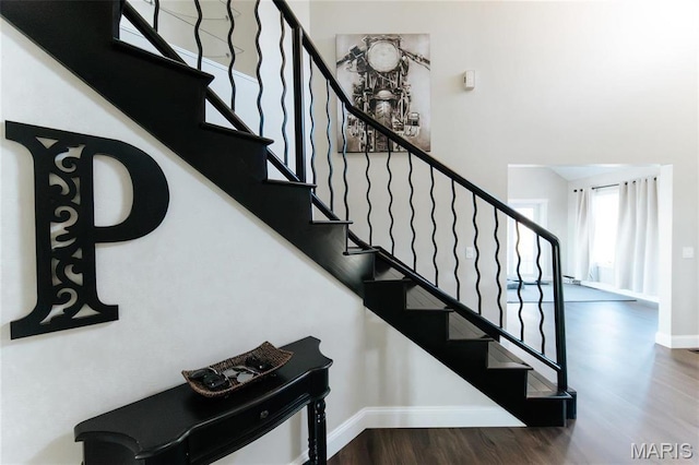 10605 Larson Ln, Rolla, MO 65401 - staircase featuring baseboards, wood finished floors, and a towering ceiling