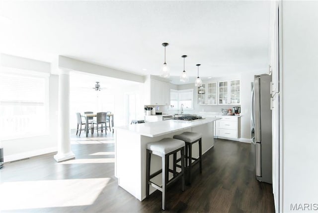 10605 Larson Ln, Rolla, MO 65401 - kitchen with stainless steel appliances, decorative columns, a center island, and white cabinetry