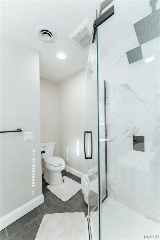 10605 Larson Ln, Rolla, MO 65401 - bathroom with baseboards, toilet, and a marble finish shower