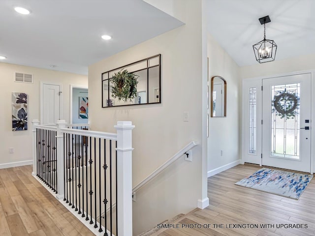 entryway with wood finished floors, baseboards, a chandelier, and recessed lighting