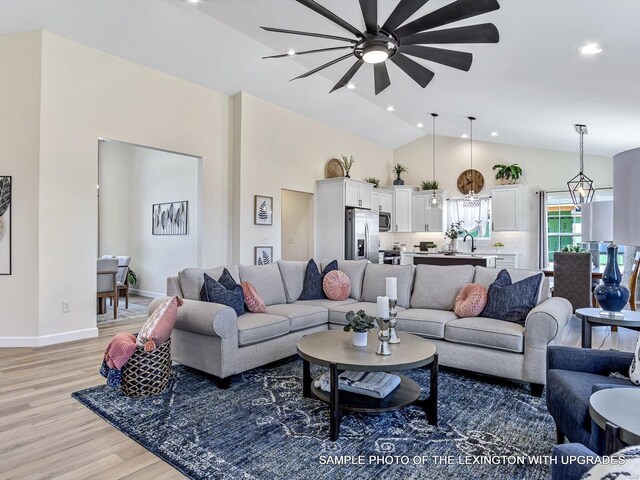 living room with light wood-style flooring, ceiling fan, recessed lighting, high vaulted ceiling, and baseboards