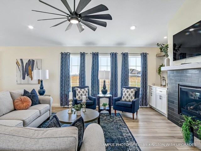 living area featuring ceiling fan, light wood-style floors, a fireplace, and recessed lighting