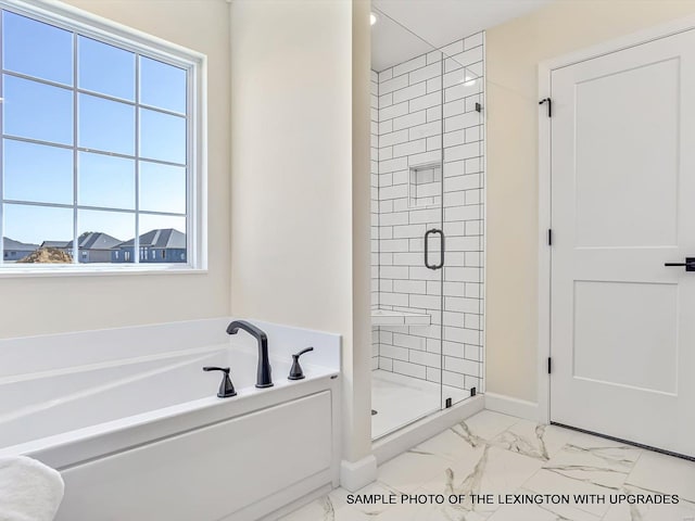 bathroom with marble finish floors, plenty of natural light, a stall shower, and a bath