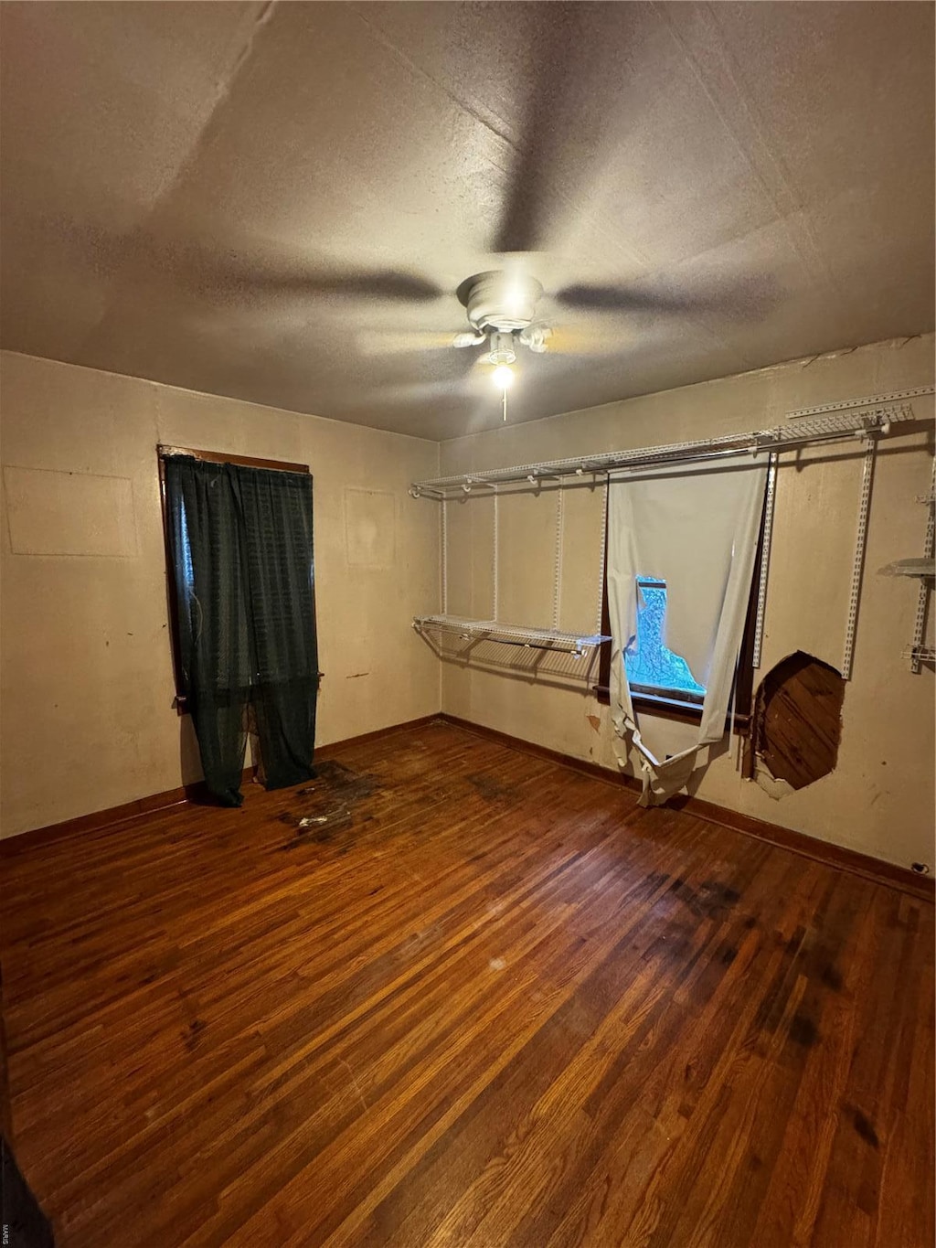 unfurnished bedroom with wood finished floors, a ceiling fan, and a textured ceiling