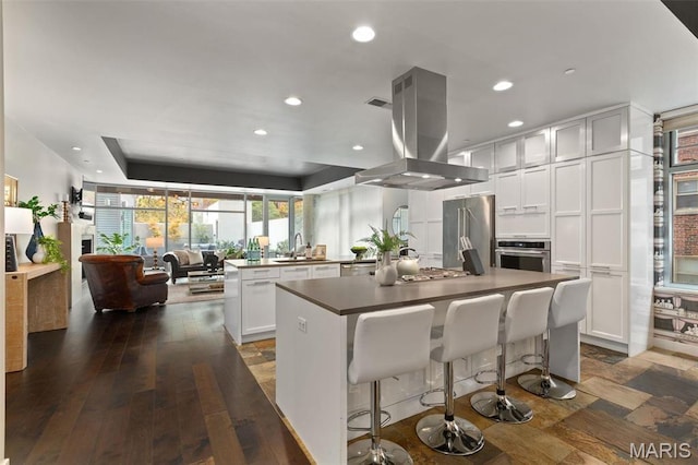 4545 Lindell Blvd Unit 3, Saint Louis, MO 63108 - kitchen featuring island range hood, appliances with stainless steel finishes, a sink, a kitchen island, and recessed lighting