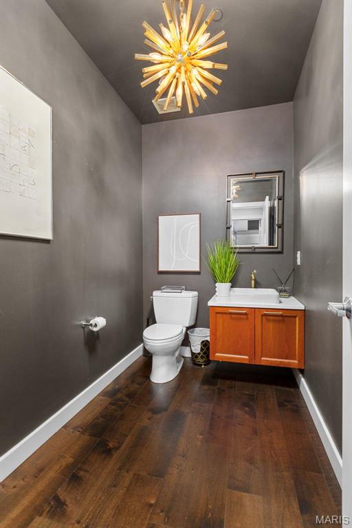 4545 Lindell Blvd Unit 3, Saint Louis, MO 63108 - half bath with hardwood / wood-style flooring, toilet, a chandelier, vanity, and baseboards