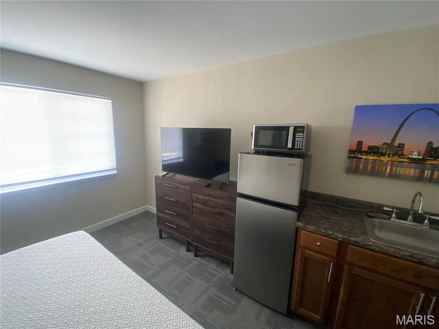 1 Proactive Dr, New Florence, MO 63363 - kitchen featuring appliances with stainless steel finishes, a sink, dark countertops, and baseboards