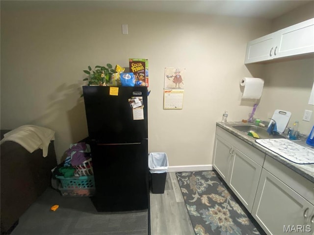 1 Proactive Dr, New Florence, MO 63363 - kitchen featuring freestanding refrigerator, wood finished floors, a sink, baseboards, and white cabinetry