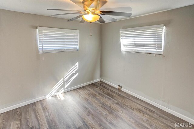 spare room featuring a ceiling fan, wood finished floors, and baseboards