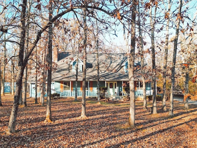 view of front of home featuring covered porch and a chimney