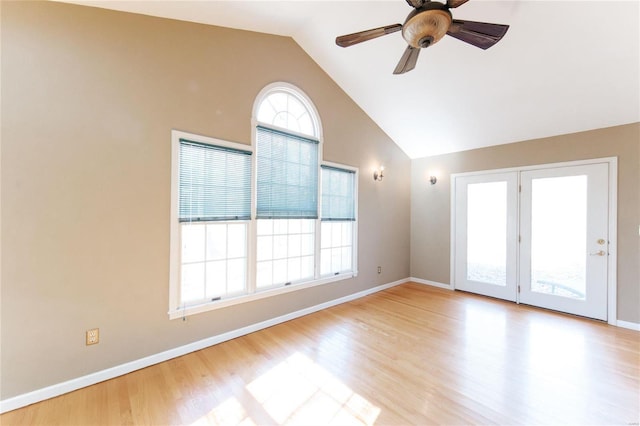 empty room featuring lofted ceiling, wood finished floors, a ceiling fan, and baseboards
